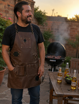 Hombre asando carne con Mandil Parrillero Artesanal de Piel Cafe MenCity en patio al atardecer