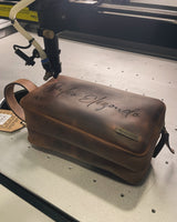 Proceso real de grabado laser sobre necessaire de piel MenCity - autenticidad del oficio mexicano